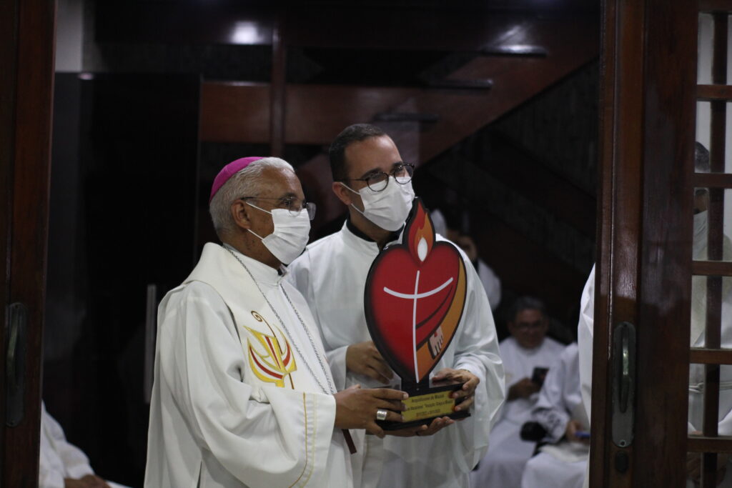 Dom Antônio Carlos Cruz Santos segura escultura com a logo o 3º Ano Vocacional da Igreja do Brasil